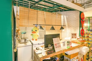 Un comptoir de caisse équipé d’un ordinateur, d’une caisse enregistreuse, d’un panneau indiquant qu’il est interdit de fumer et d’un canard en peluche.