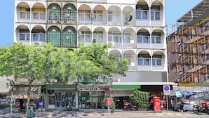 Un edifici de diversos pisos amb balcons, un cartell amb la inscripció 'Bangkok Hostel' i una botiga amb un cartell que diu 'Bangkok Hut'.