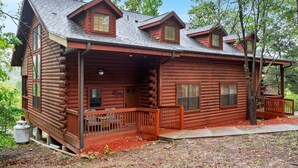 A log cabin with a porch, a chimney, and a small deck. - Unwind and Relax! Walk-in Log Cabin with Gas Fireplace and Screened Balcony (Branson)