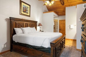 A wooden bed with white bedding in a room with a wooden ceiling and a framed picture on the wall. - Unwind and Relax! Walk-in Log Cabin with Gas Fireplace and Screened Balcony (Branson)