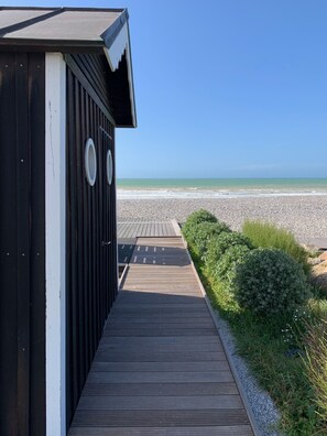 A wooden pathway leading to a building with a view of the beach. - Beautiful house in the countryside near the ocean (Longueil)