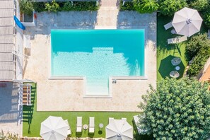 Una piscina al aire libre, una piscina climatizada, tumbonas