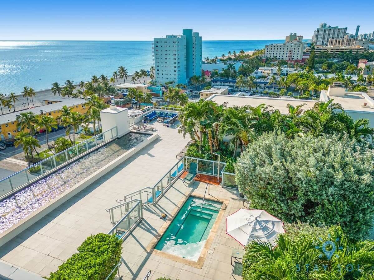 Zona de piscina en la azotea con vistas al océano y al paisaje urbano.