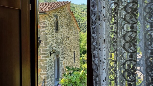 Edifici de pedra amb teulada d'àmples rajoles, una petita finestra i una porta.