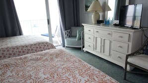 A hotel room with two beds, a dresser, a chair, a TV, and a window with curtains. - El Capitan, Ocean City, MD, USA unit 203 located on the boardwalk and ocean at 4th street (Ocean City)