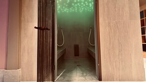 Un baño moderno con ducha, puerta de cristal y suelo de baldosas.