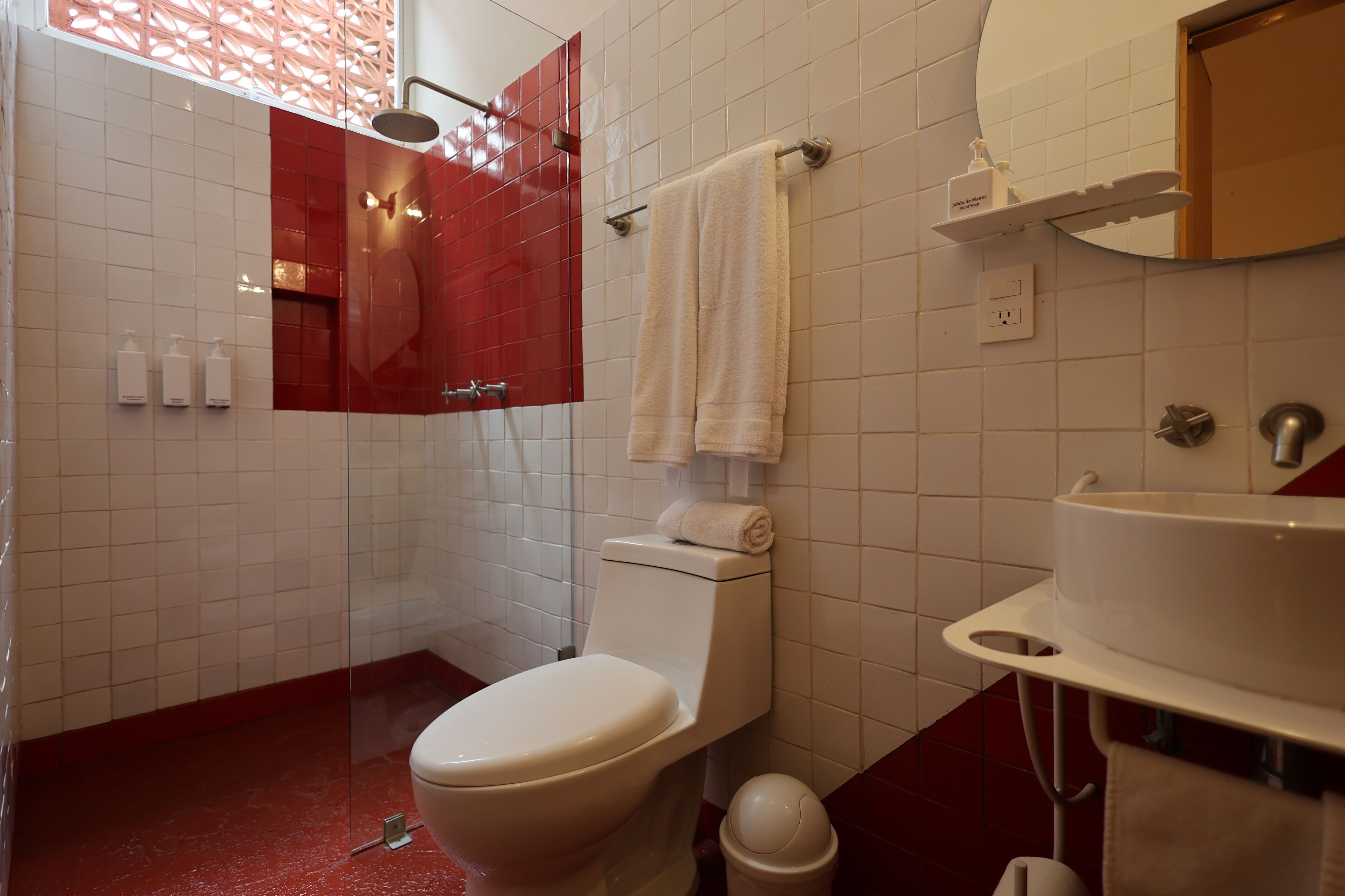 Un bagno con il water, un lavandino, uno specchio e una doccia.