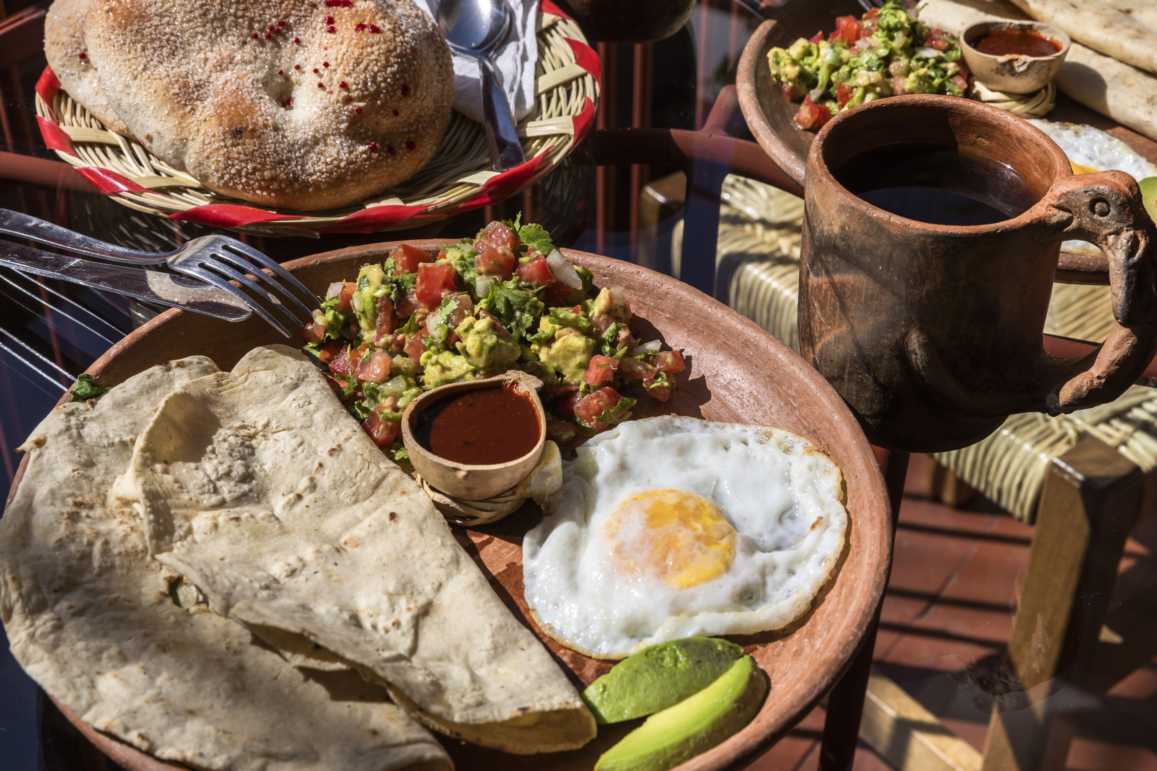 A breakfast plate with eggs, avocado, and salsa.