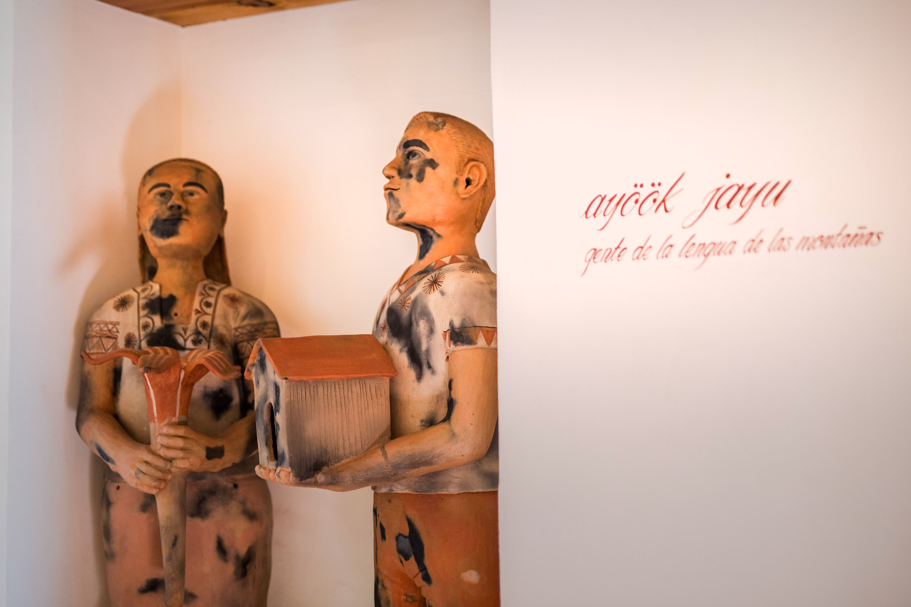 A sculpture with a text on the wall.