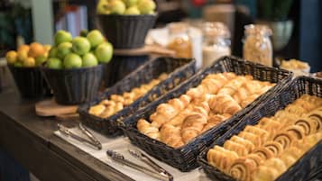 A bakery display with baskets of apples and croissants.