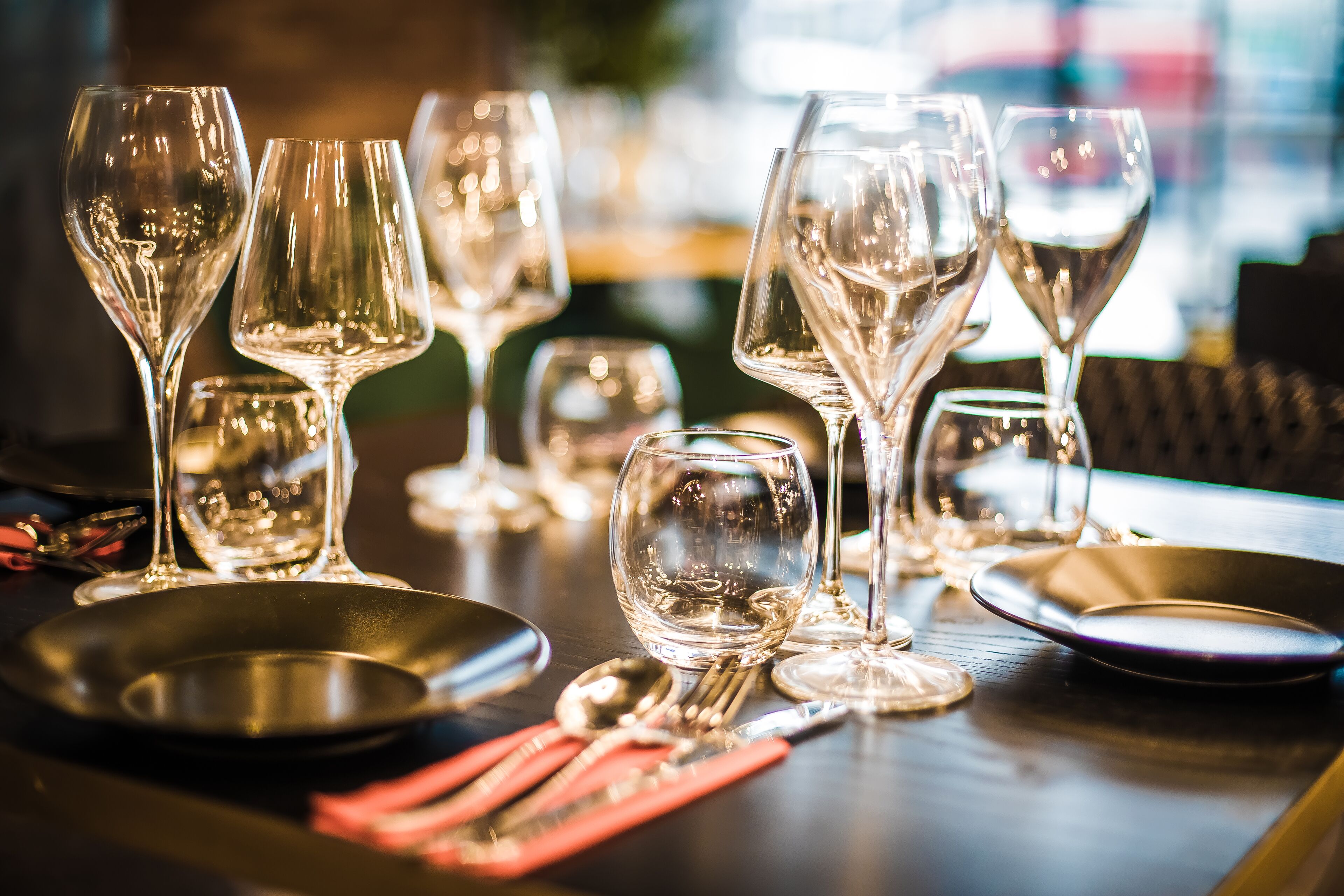 A table set with wine glasses, plates, and cutlery, indicating a dining area.