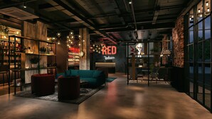 Ein modernes Interieur mit einem blaugrünen Sofa, einem Empfangstresen und einer Ziegelwand.