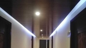 A narrow hallway with a tiled floor and wooden doors on both sides. - La Mansión del Faro (Tecolutla)