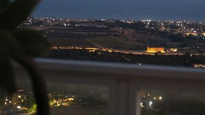 A nighttime view of a cityscape with a prominent building illuminated in the distance.