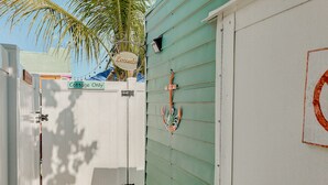 A gated entrance with a 'Cottage Only' sign, a 'Laundry' sign, and a decorative anchor on the wall. - Naut 2 Shabby Cottage-Awesome Pool Area, Pine Ave location close to everything (Anna Maria)