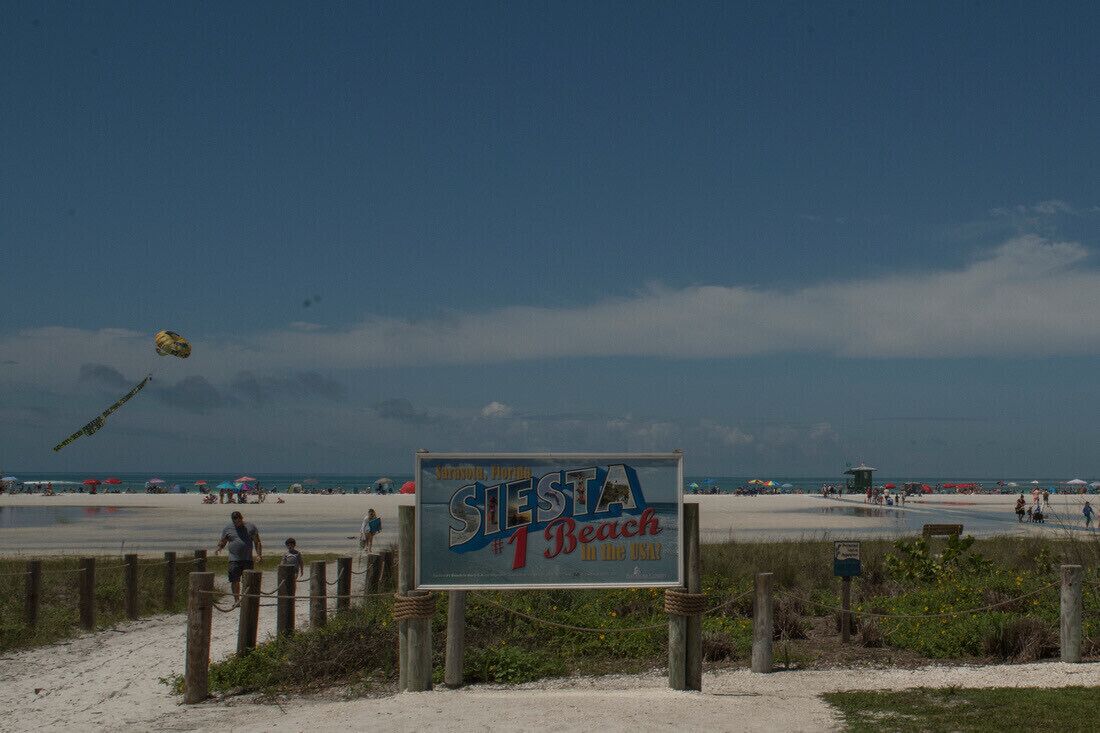 Un panneau sur la plage avec l’inscription : « Siesta Beach, la plus belle plage des États-Unis. »
