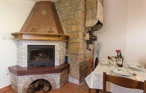 Enjoy a warm meal by the fireplace in this inviting dining area.