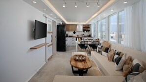 Une cuisine moderne avec des meubles blancs, un réfrigérateur noir et un coin repas comprenant une table et des chaises en bois.