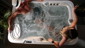 Un bain à remous où se trouvent deux personnes, l’une portant un chapeau et l’autre une montre.