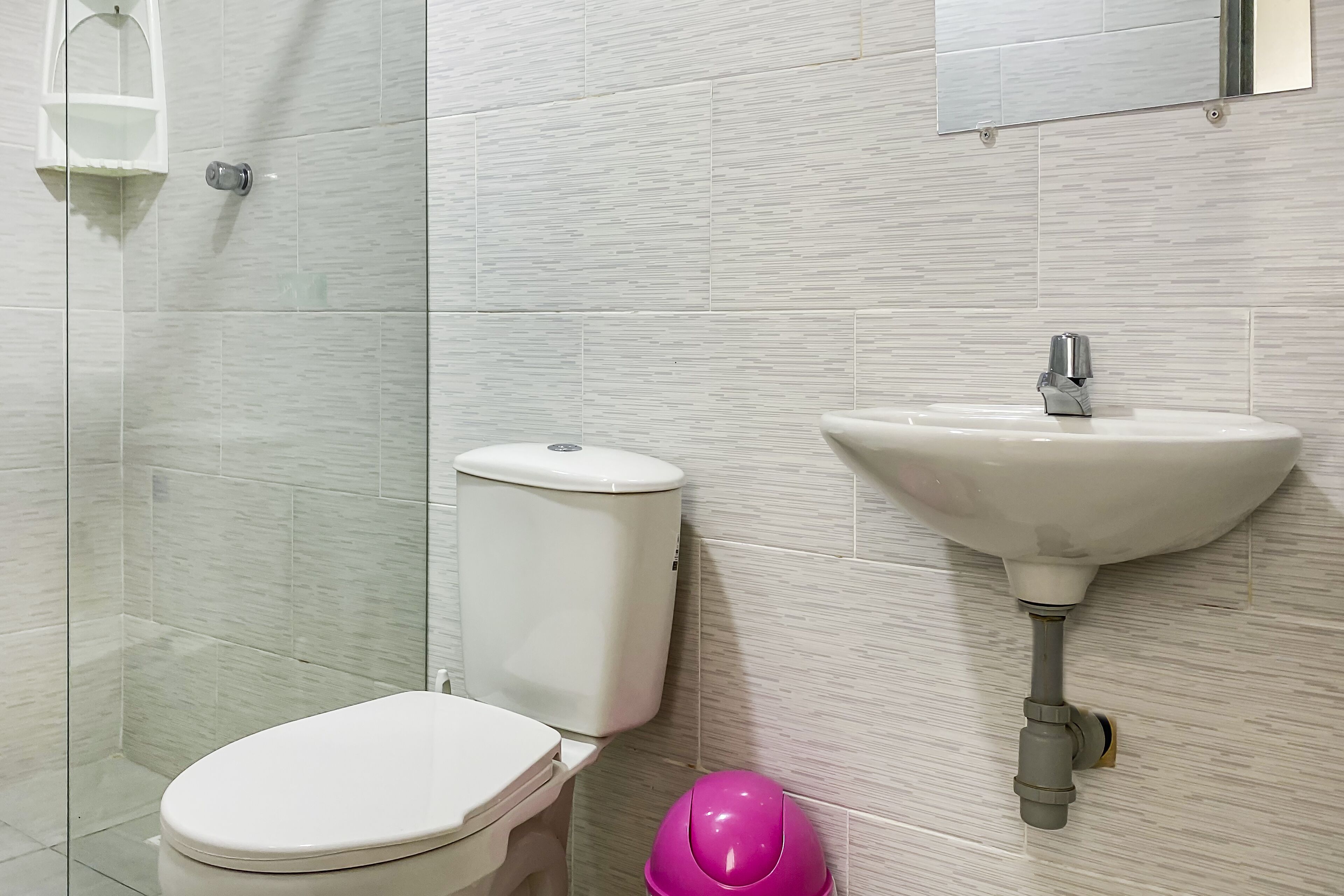 A bathroom with a toilet, sink, and shower.