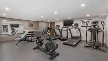 A gym with various exercise equipment including treadmills, an elliptical, and a stationary bike.