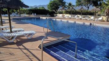 Alberca al aire libre y camastros