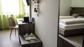A hotel room with a desk, chair, and a bed with a headboard.