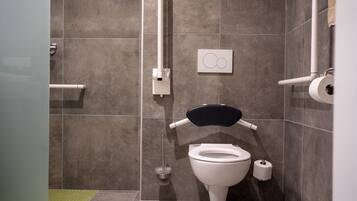 Un baño moderno con inodoro, bidé y secador de manos.