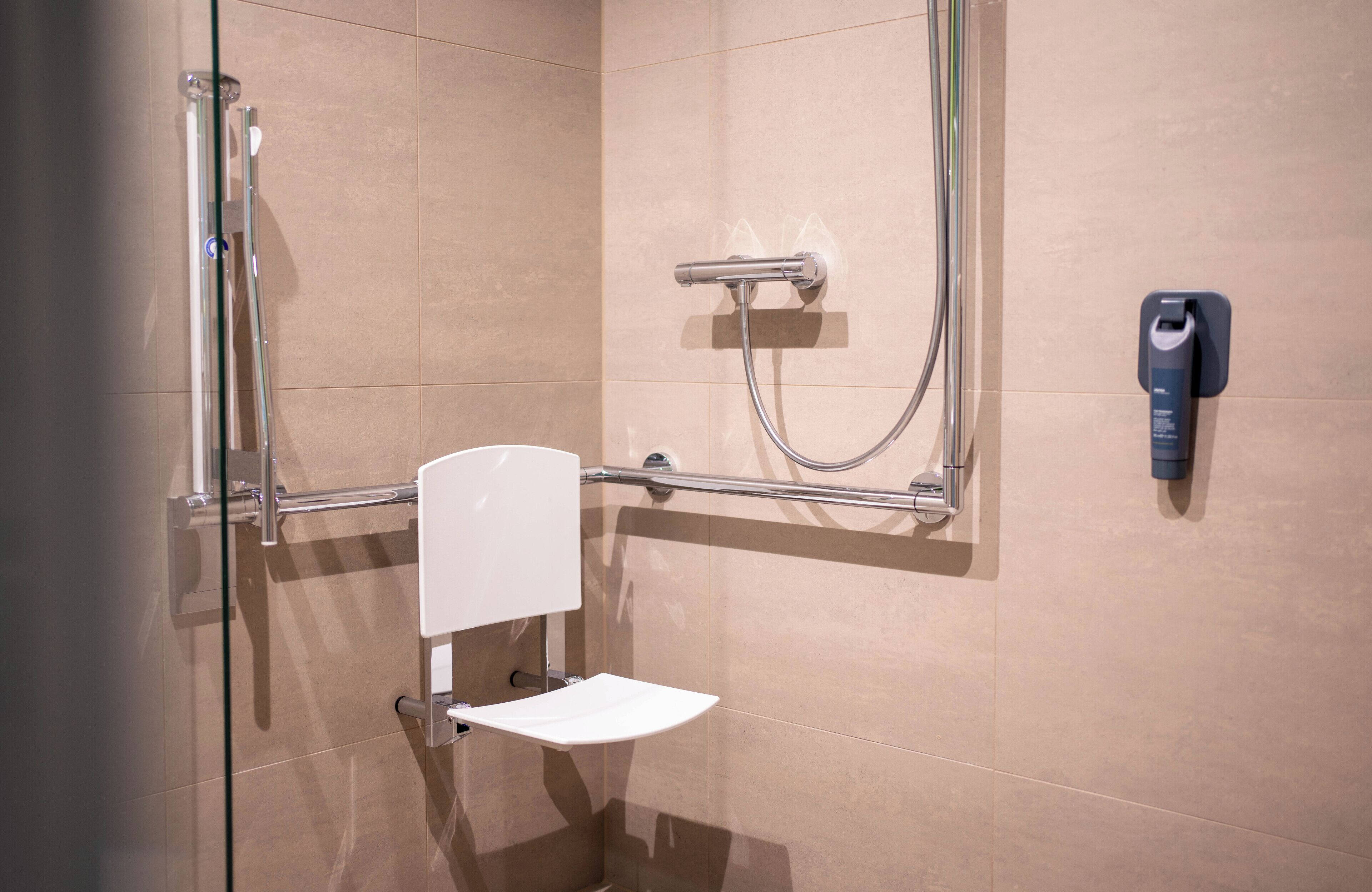 A modern bathroom with a glass shower enclosure, a white toilet, and a wall-mounted bidet.