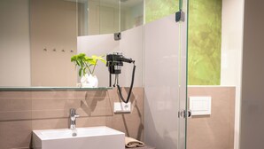 A modern bathroom with a rectangular sink, a glass shower enclosure, and a toilet. - eee hotel Gunskirchen (Gunskirchen)