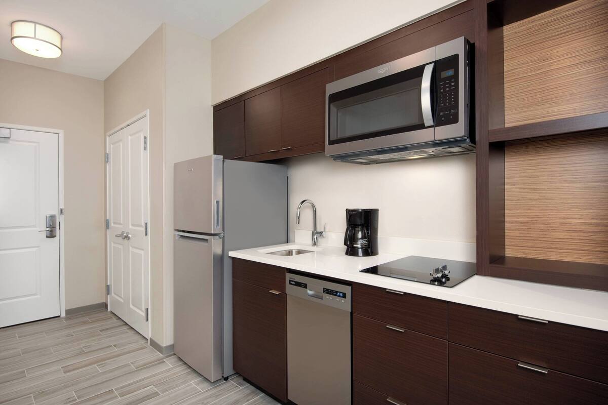 A modern kitchen with stainless steel appliances, a dishwasher, and a coffee maker.