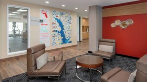 A modern lobby with leather seating, a round table, and a map on the wall. - TownePlace Suites by Marriott Niceville Eglin AFB Area (Niceville)