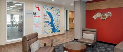 A modern lobby with leather seating, a round table, and a map on the wall.