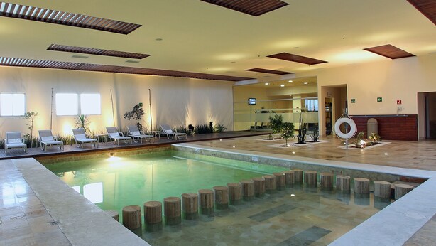 Un espace piscine avec des chaises longues et une bouée de sauvetage.
