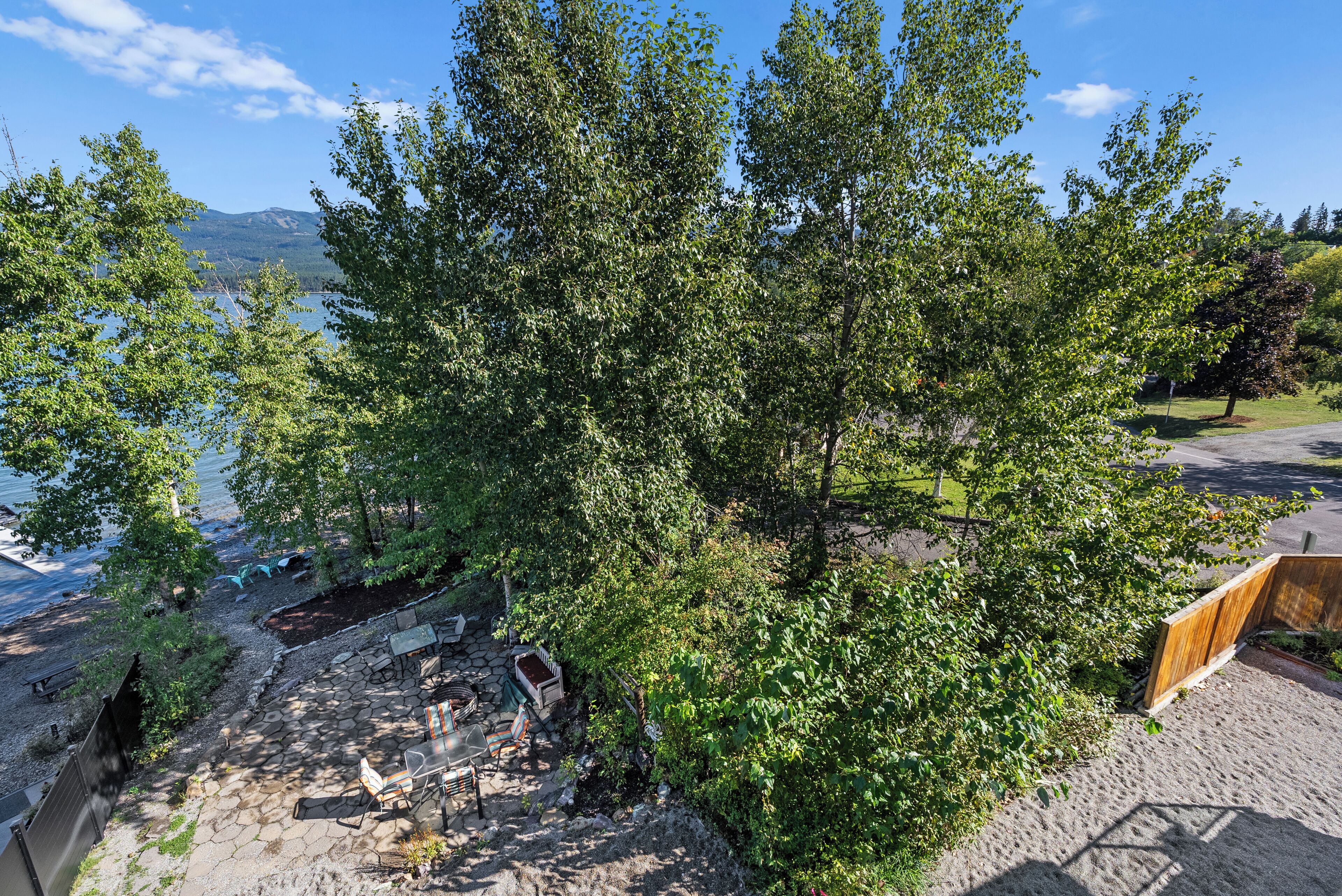 A patio area with stone flooring, outdoor furniture, and a view of a lake and mountains.