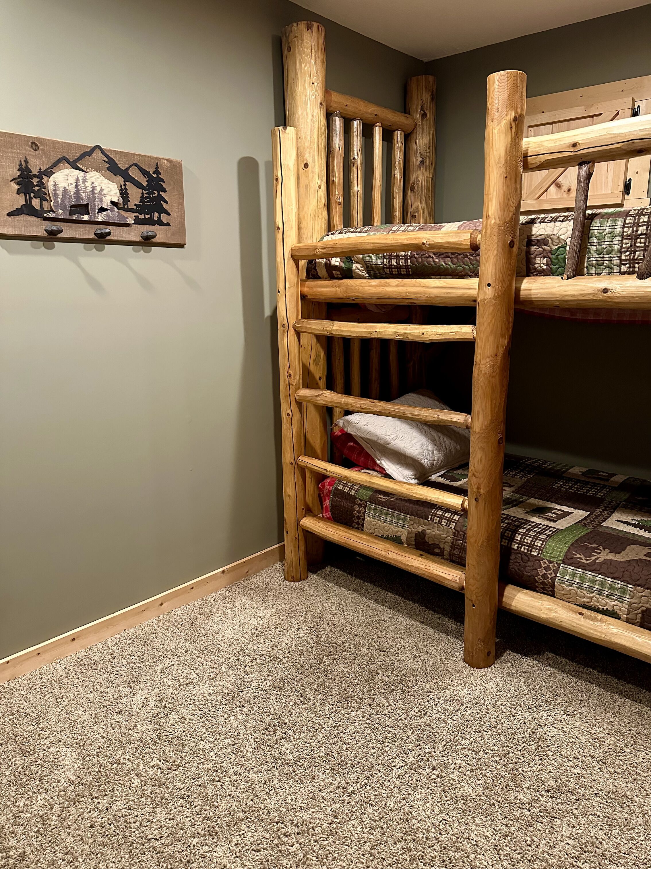 A bunk bed with a wooden frame and a wall-mounted decoration.
