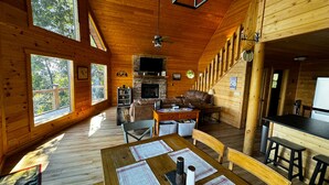 A cozy cabin interior with a dining area, seating, a fireplace, and a kitchen. - Best view in Georgia. Unbelievably peaceful. Amazing night sky. (Morganton)