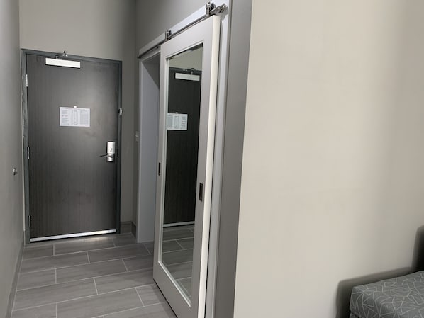 A hallway with a closed door on the left and a sliding door on the right.