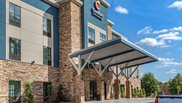 A Comfort Inn & Suites building with a stone facade, large windows, and a covered entrance area. - Comfort Inn & Suites Olive Branch Old Towne (Olive Branch)