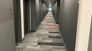 A long, narrow hallway with doors on both sides, carpeted floor, and a ceiling with recessed lighting. - Comfort Inn & Suites Olive Branch Old Towne (Olive Branch)