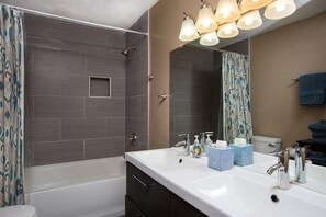 Bañera con ducha, toallas, papel higiénico