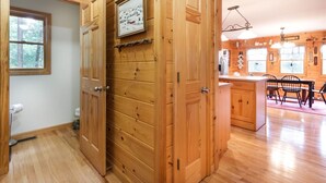 A wooden interior with a kitchen area, wooden cabinets, and a dining table.