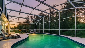 An indoor swimming pool with a glass ceiling, surrounded by lounge chairs and a table. - Near Theme Parks! In-Ground 3 BR Pool Home, Sleeps 7, Total Privacy! (Kissimmee)