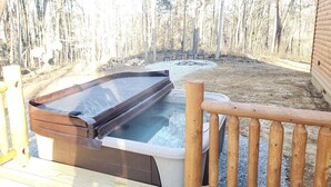 A hot tub on a wooden deck with a view of a forest. - King of Hearts.  Secluded Hocking Hills cabin! (Rockbridge)