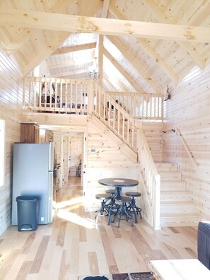 Ein Holzblock-Interieur mit einer zentralen Treppe, einem Essbereich und einer Küche.