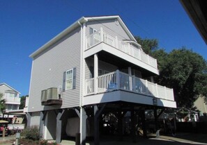 A two-story building with a balcony and a covered porch area.