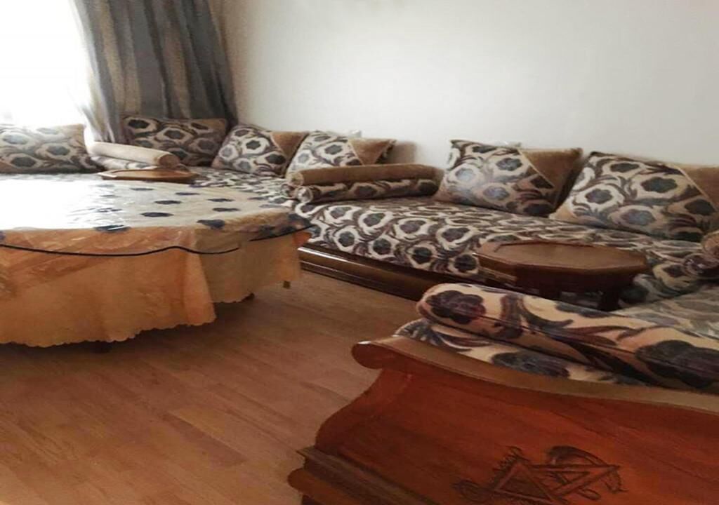 A living room with a sofa set, a coffee table, and patterned cushions.