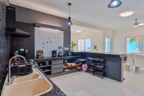 A modern kitchen with a sink, stove, and various appliances.
