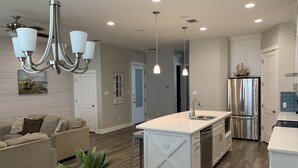 A modern kitchen with a central island, stainless steel appliances, and pendant lighting. - HUGE 4BR/3BA! Pool, Beach & Boat Slip! 4 Car Garage  (Corpus Christi)
