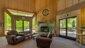 A wooden interior with leather sofas, a fireplace, and large windows. - Family Condo in Carnelian Woods (Carnelian Bay)